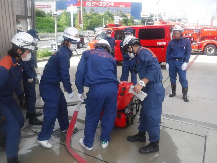 写真：消防ポンプの取扱い説明を受ける消防団員