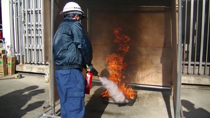 写真：実際に炎を出して消火器を使う消防団員
