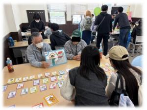 防災カードゲームを行う防コミの皆さんと市民の方