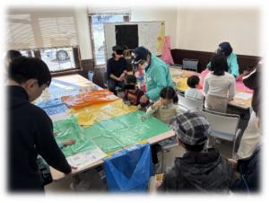 ポンチョづくりを行う防コミの皆さんと市民の方