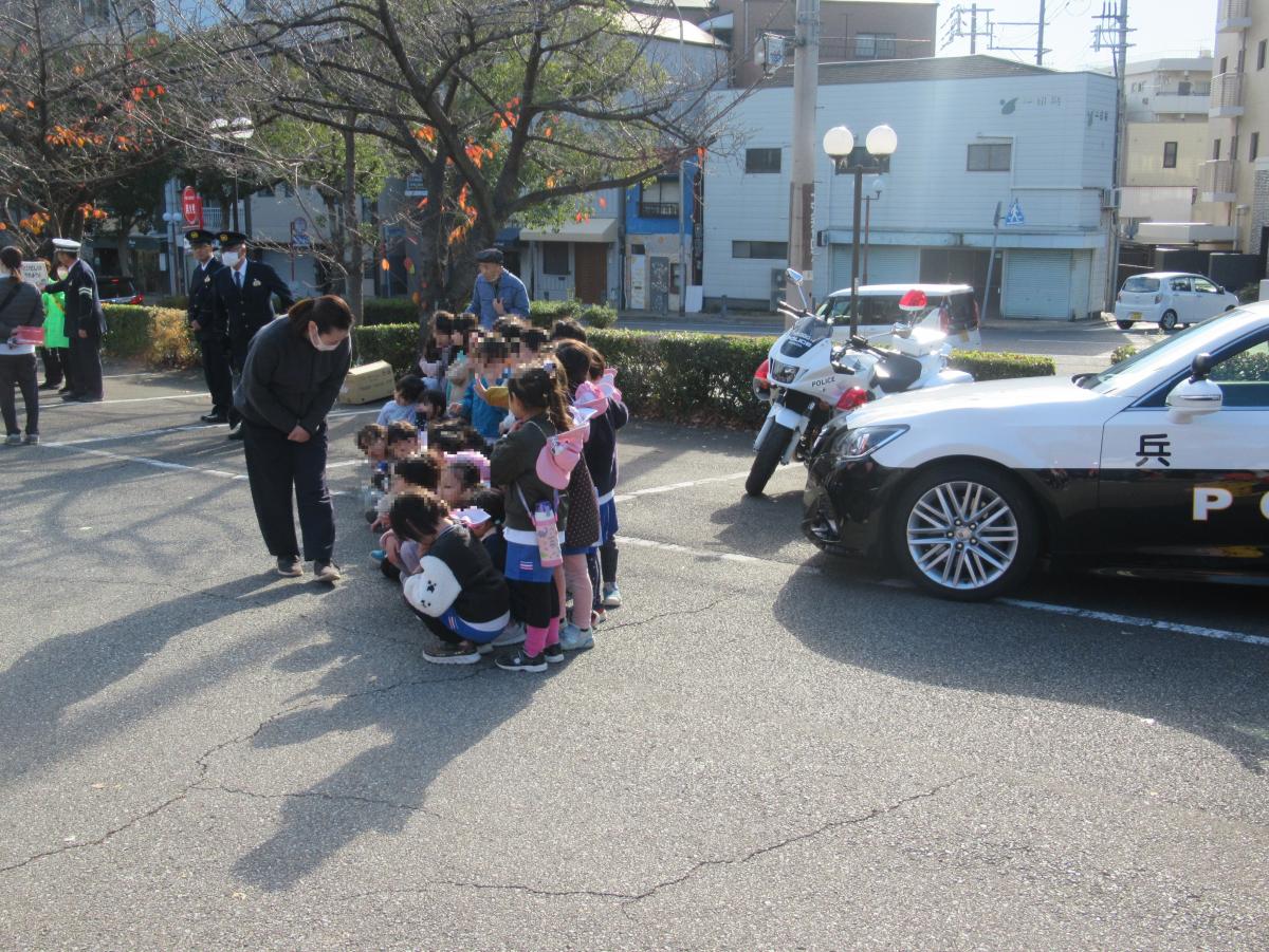 パトカーや白バイと記念撮影する子ども達