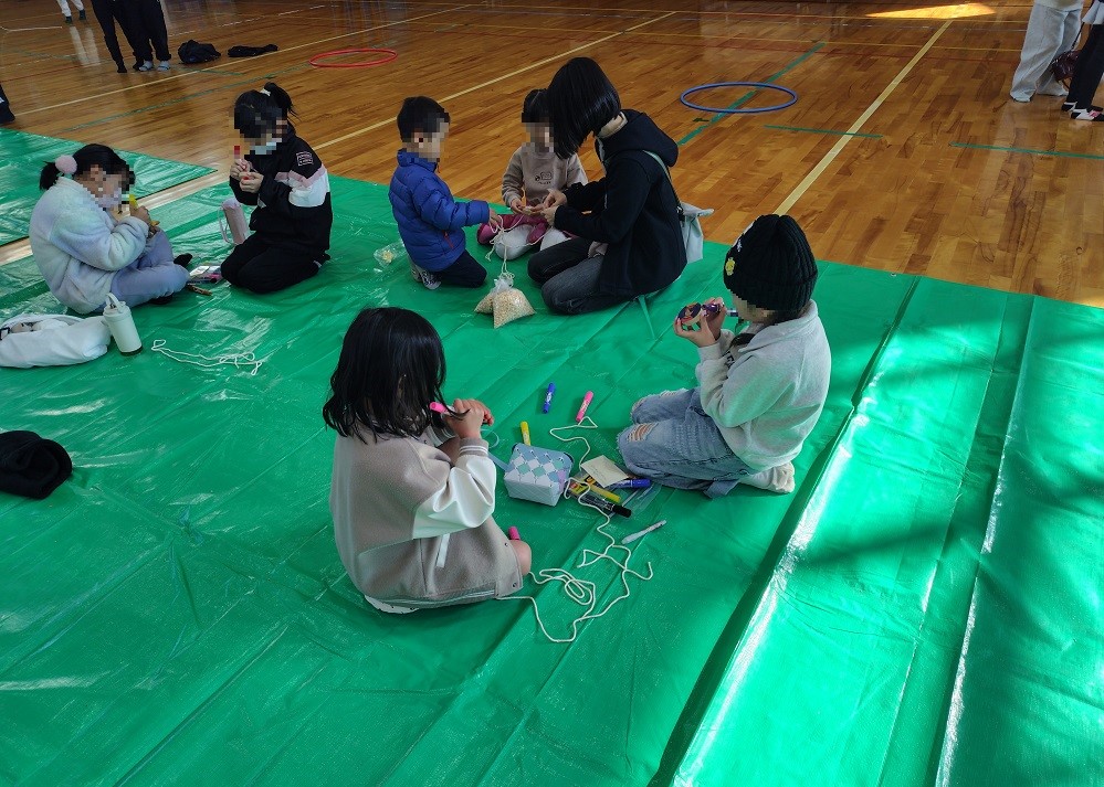 子どもたちがコマに色を塗っている様子