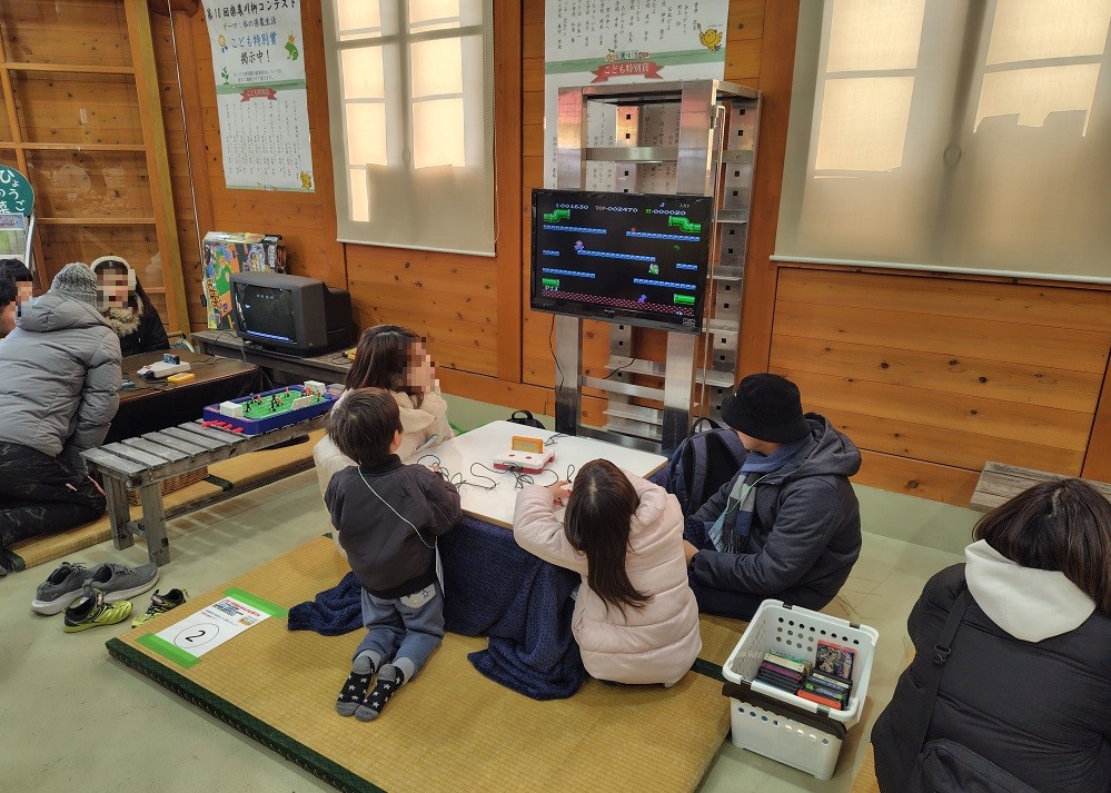 こたつを囲んで、昔ながらのゲーム遊びを楽しむ様子