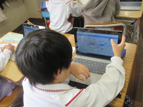 学習用パソコンを使い、考えて選択する児童