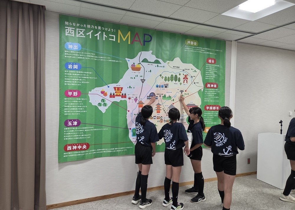 子どもたちが西区イイトコMAPを見ている様子